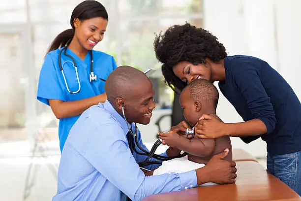 Pediatrician examining a child with parent present